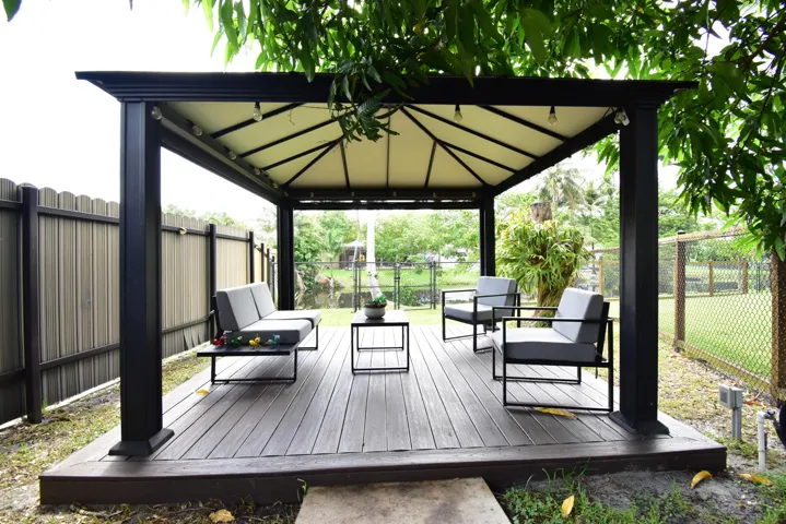 Outdoor gazebo featuring a black metal frame and light-colored canopy
