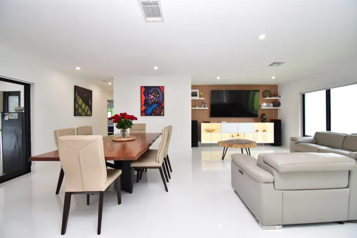 Open-concept living space with sleek white tile flooring and recessed lighting