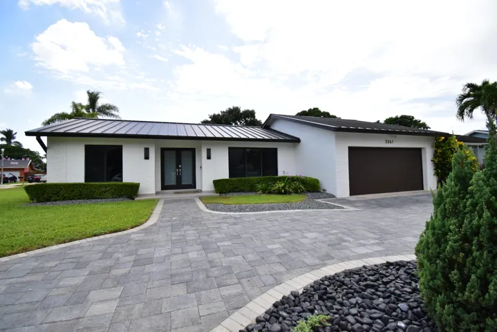 Contemporary white stucco exterior with a dark metal roof