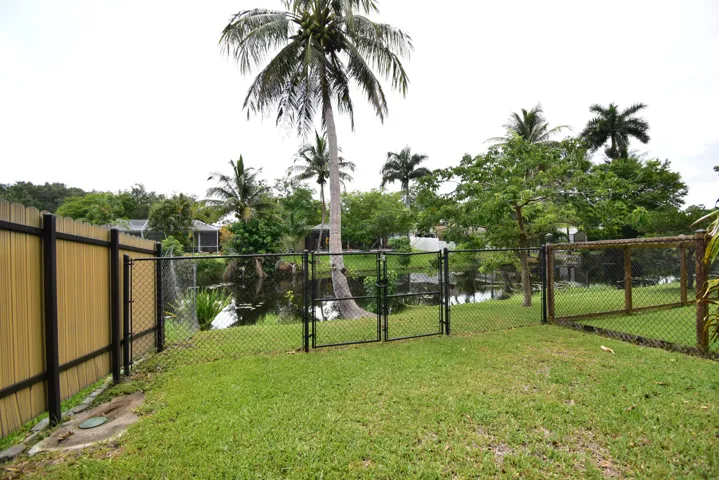 Expansive backyard featuring a manicured lawn, full fencing, and direct water access