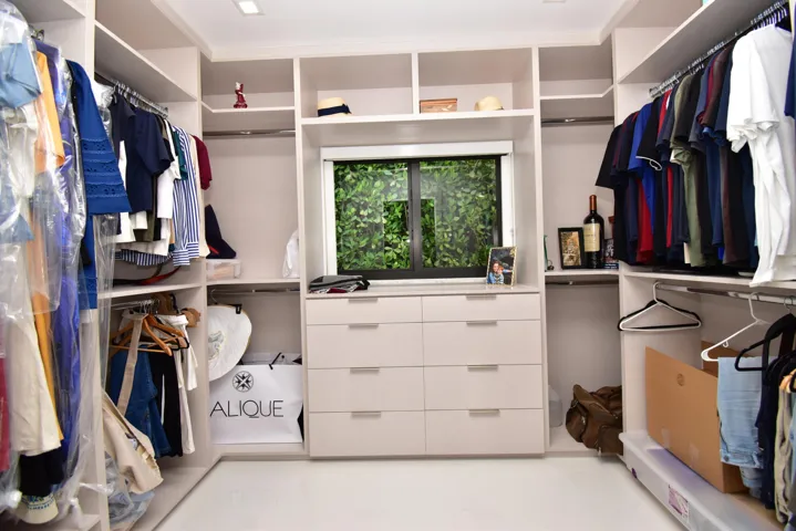 Custom closet system featuring built-in shelving, multiple hanging rods, and integrated drawer storage