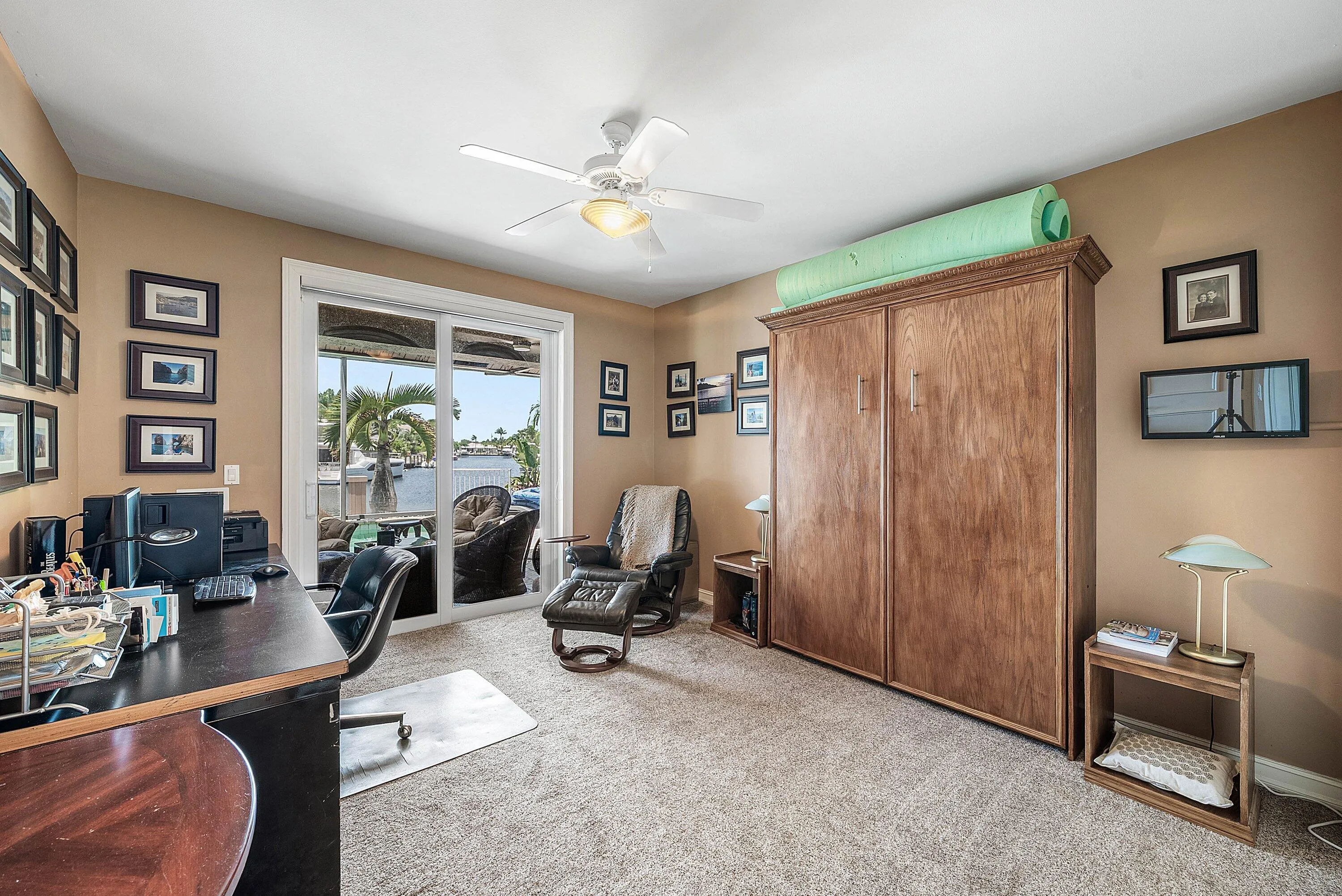 Spacious interior featuring a large sliding glass door opening to a covered loggia overlooking the waterway