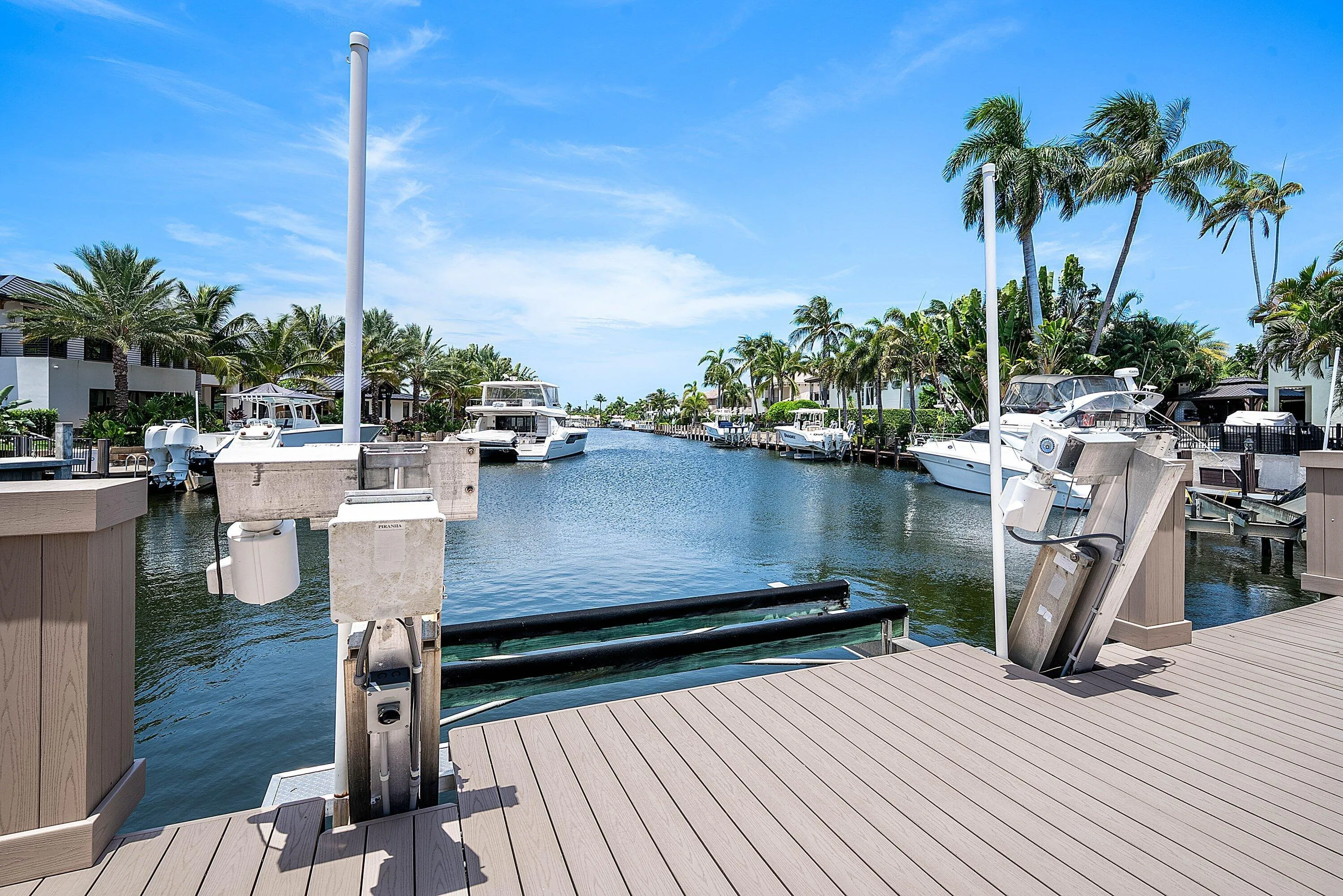 Waterfront property featuring a private boat lift, composite decking, and canal access