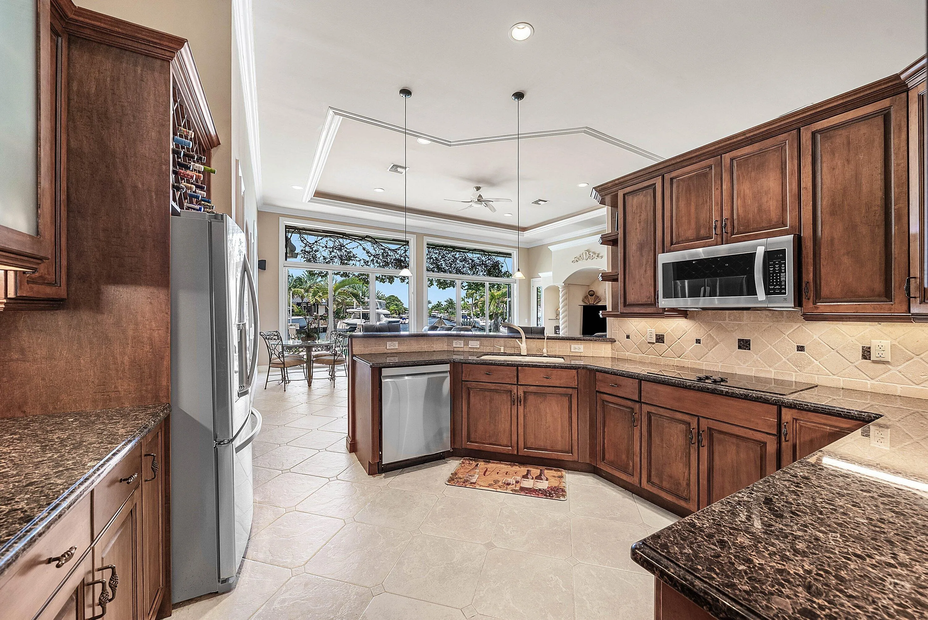 Kitchen featuring wood cabinetry, stainless steel appliances, and granite-style countertops