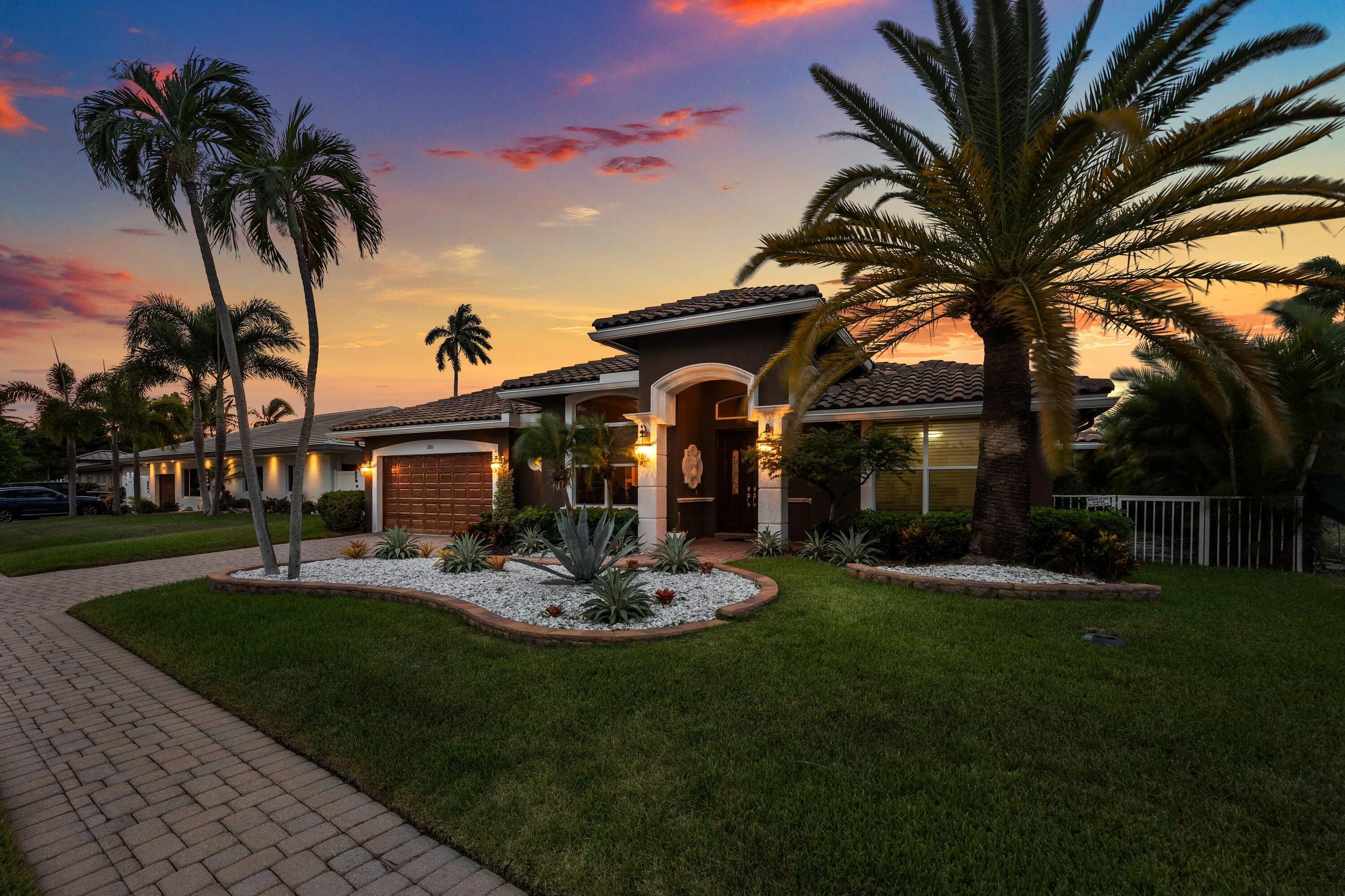 Contemporary stucco exterior with a tile roof and wood-finish garage door