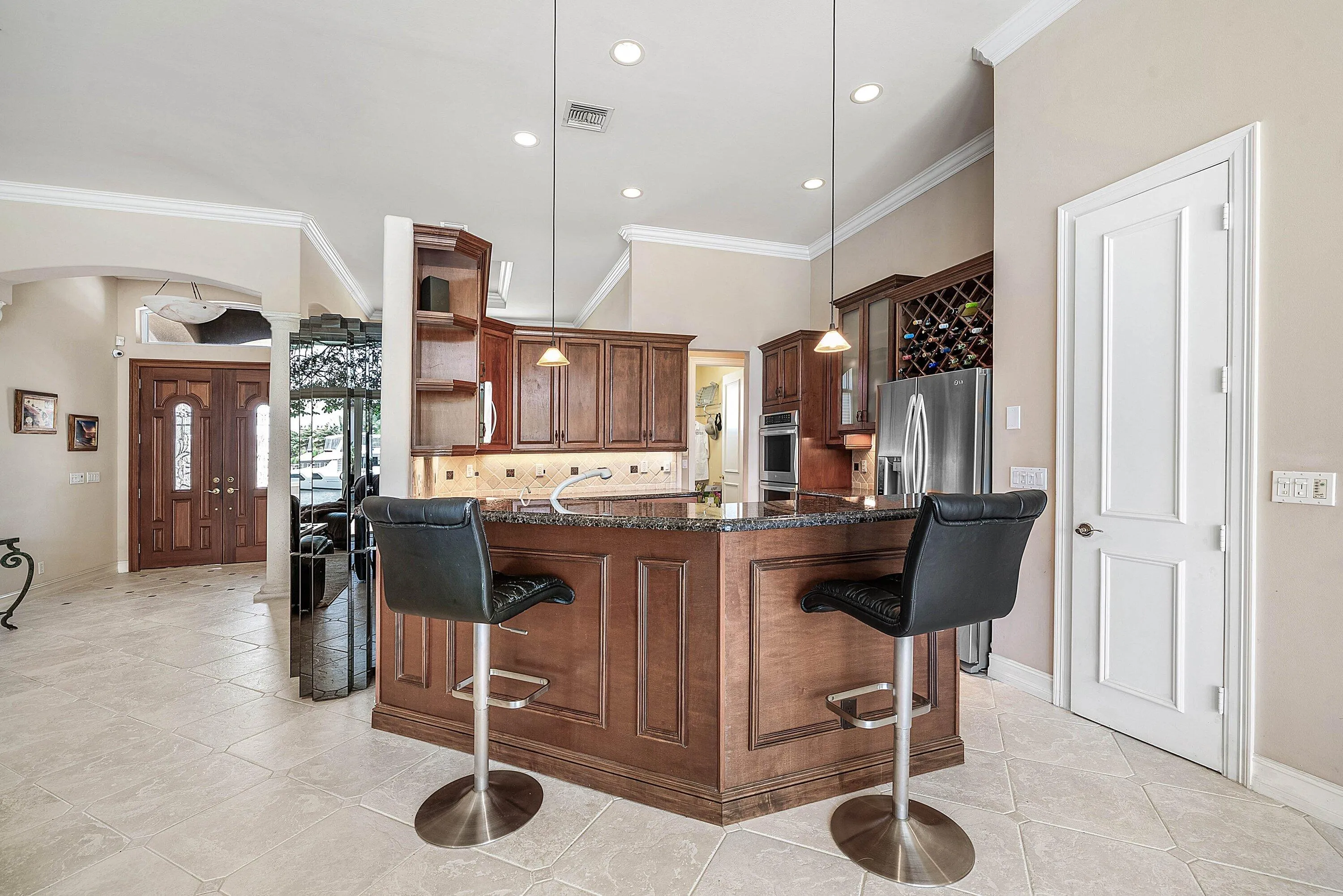 Kitchen featuring a granite-topped island with wood paneling, recessed lighting, and tile flooring