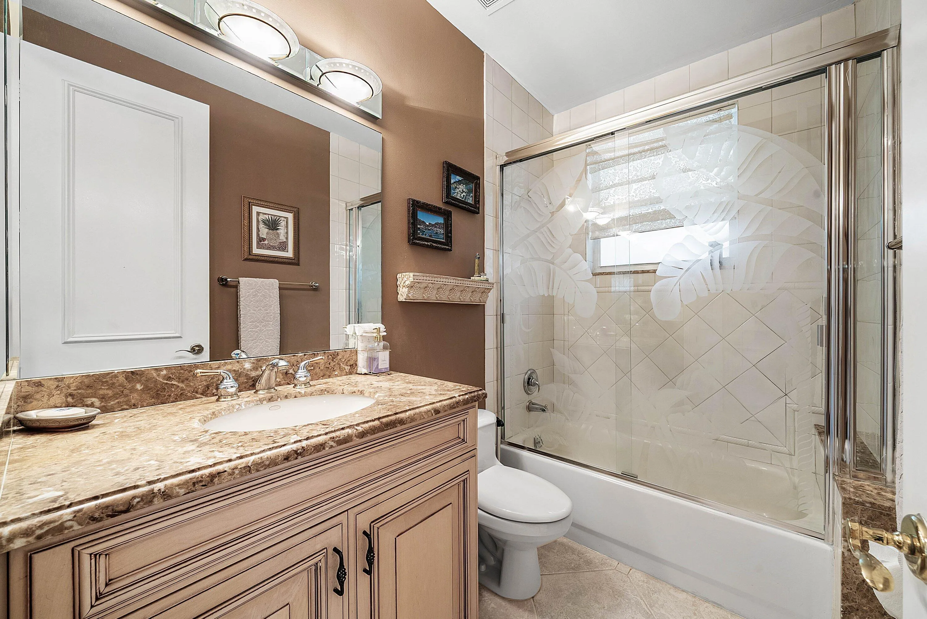 Guest bathroom featuring a vanity with a stone-finish countertop and an integrated sink, illuminated by a vanity light fixture