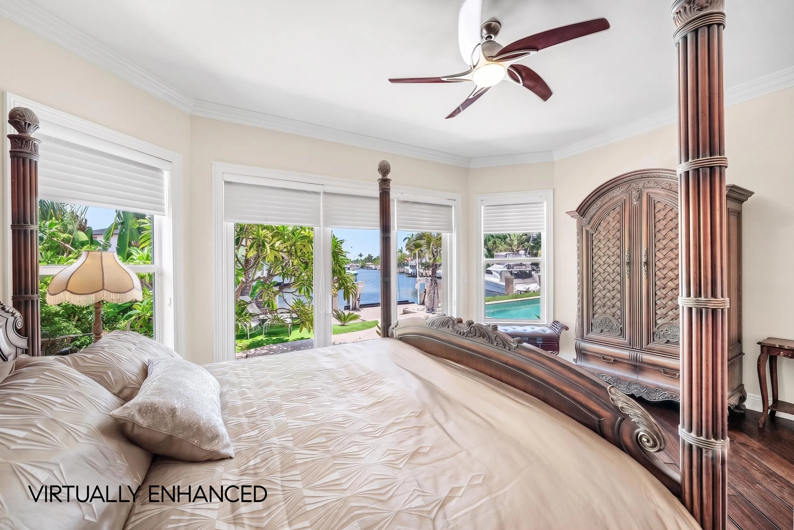 Bay window with waterfront scenery, crown molding, ceiling fan, and wood-finish flooring