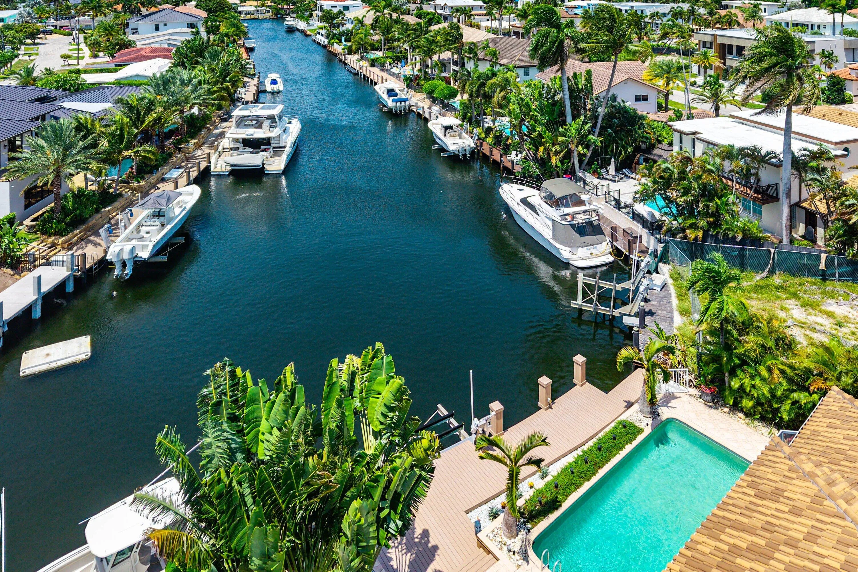 Waterfront property featuring a private boat dock, an in-ground swimming pool, and a spacious pool deck