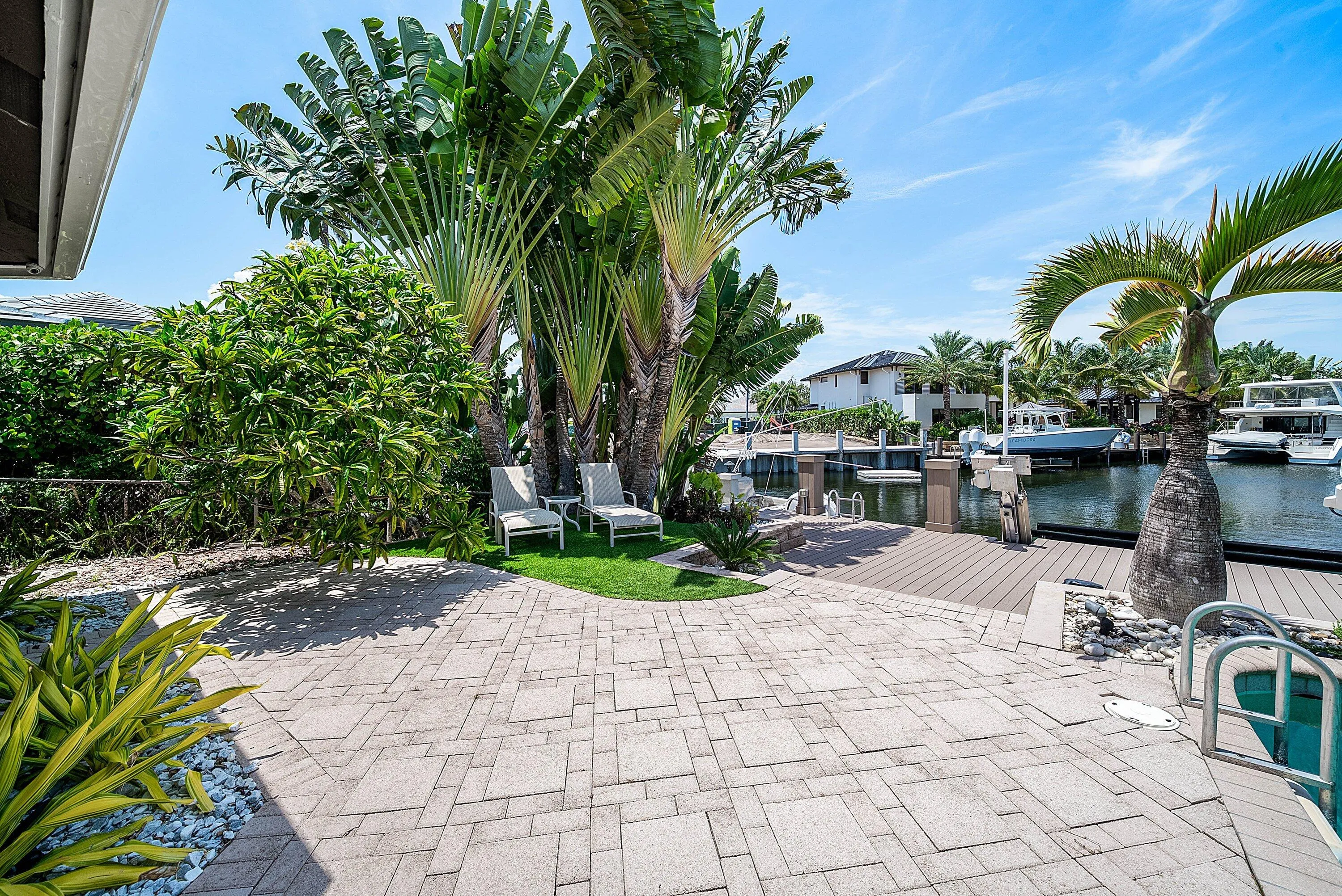 Expansive outdoor living area featuring a patterned paver patio and direct canal access