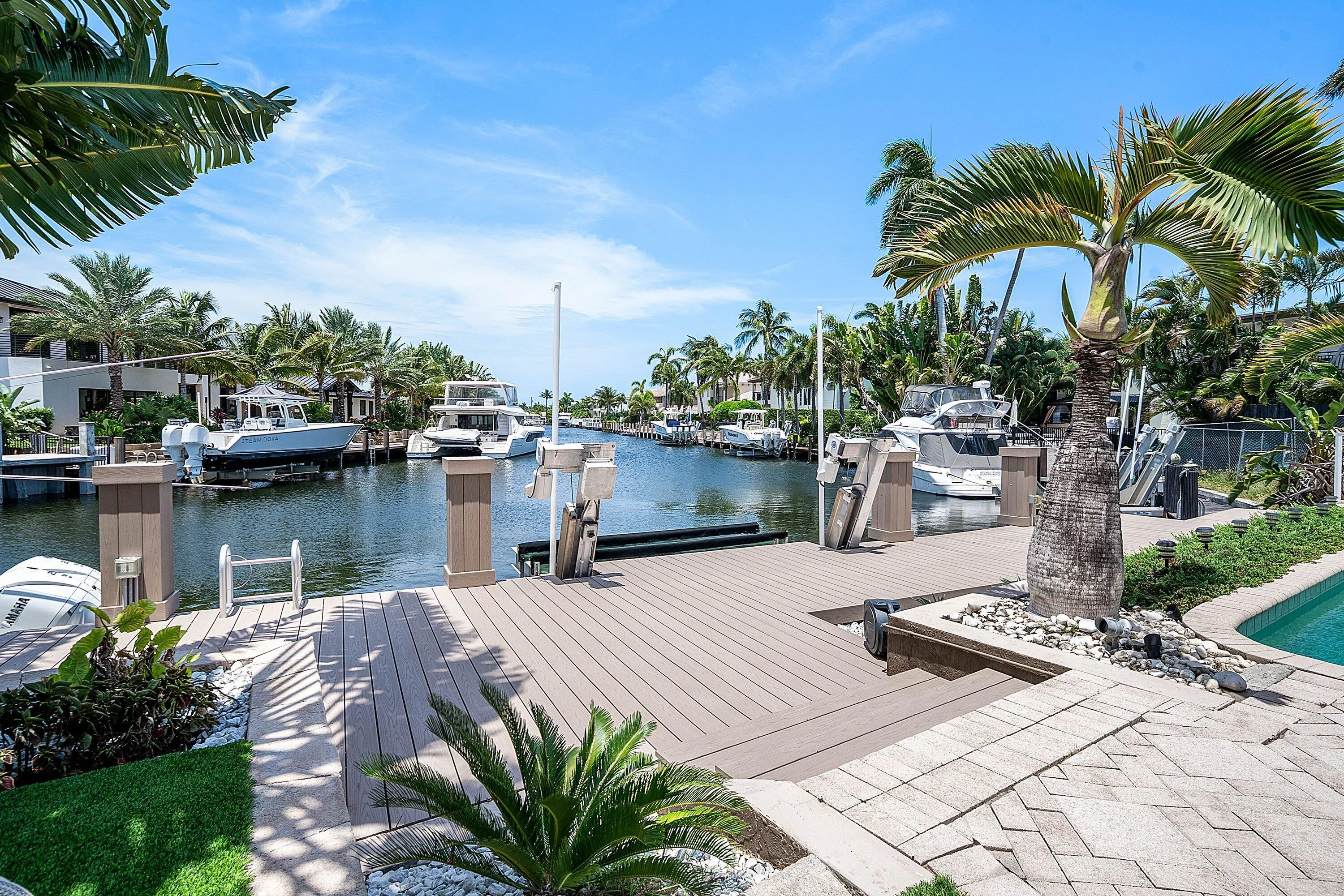 Waterfront dock with a composite decking surface, boat lift, and power pedestals