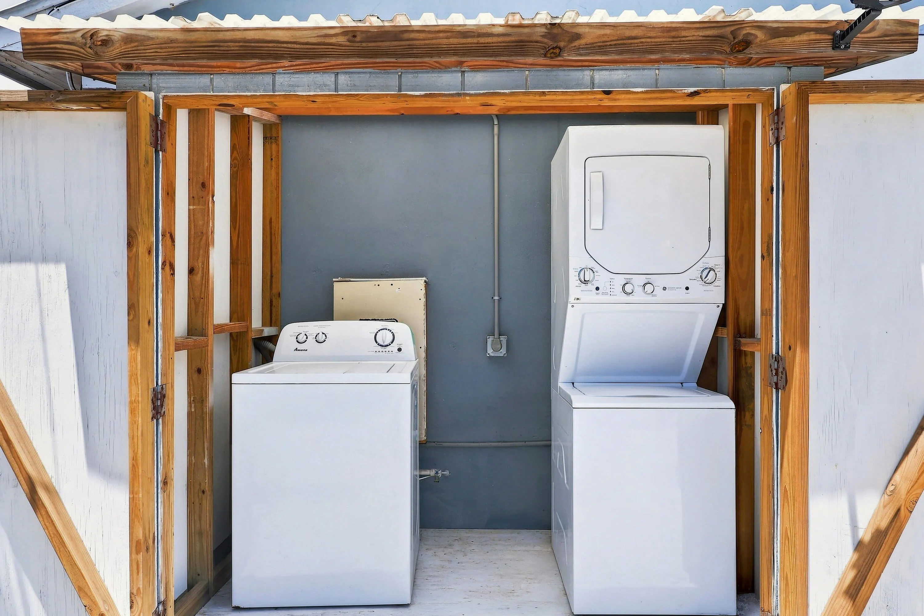 Dedicated laundry area featuring a white top-load washing machine and a white stacked washer/dryer​​‌​​​​‌​​‌‌​‌‌​​​‌‌​‌​‌​‌​​​‌​​ unit