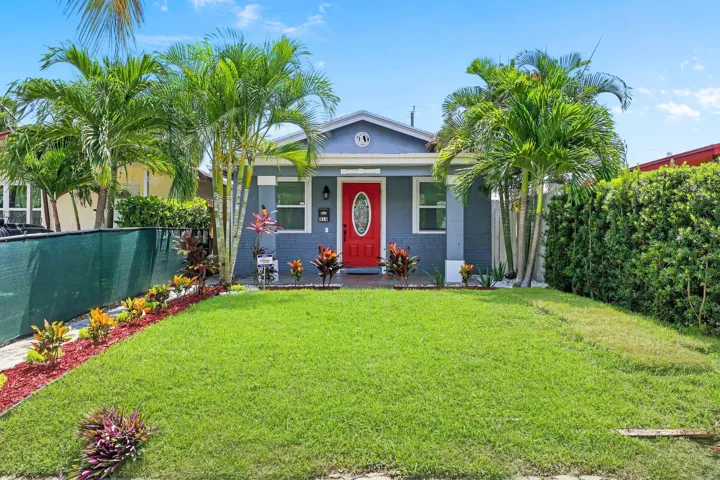 Exterior featuring a vibrant red front door, light blue siding, and white trim
