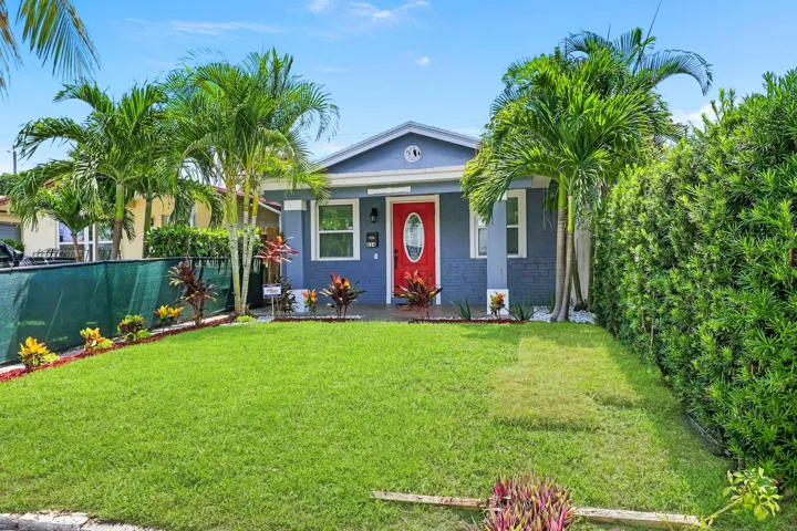 Single-story residence featuring a vibrant red entry door, light blue siding, and white trim