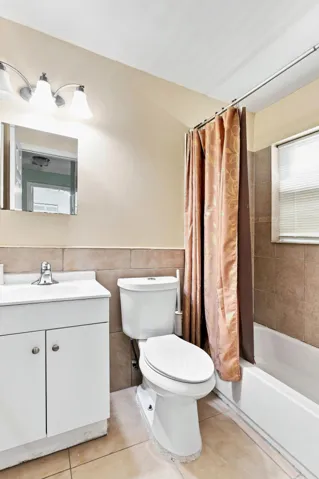 Bathroom with neutral wall tile and coordinating floor tiles