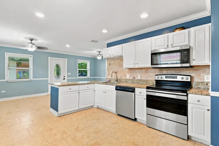 Kitchen featuring white cabinetry, stainless steel appliances, and stone-finish countertops
