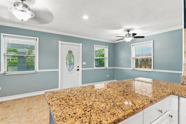 Spacious kitchen island with a granite countertop and white cabinetry