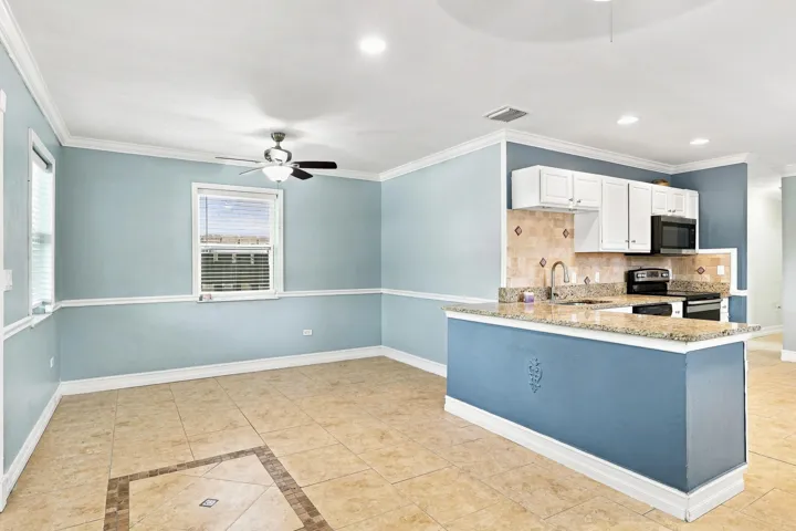 Kitchen featuring white cabinetry, granite countertops, and a tiled backsplash