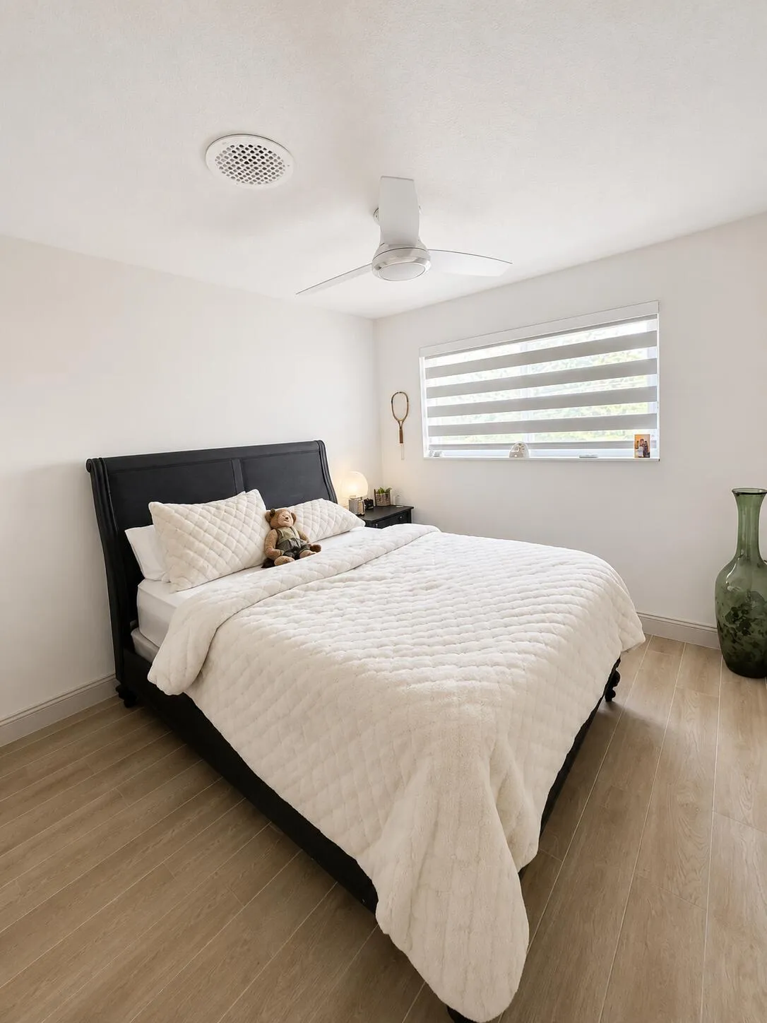 Guest Bedroom featuring wood-finish flooring, a ceiling fan, and a window with horizontal blinds
