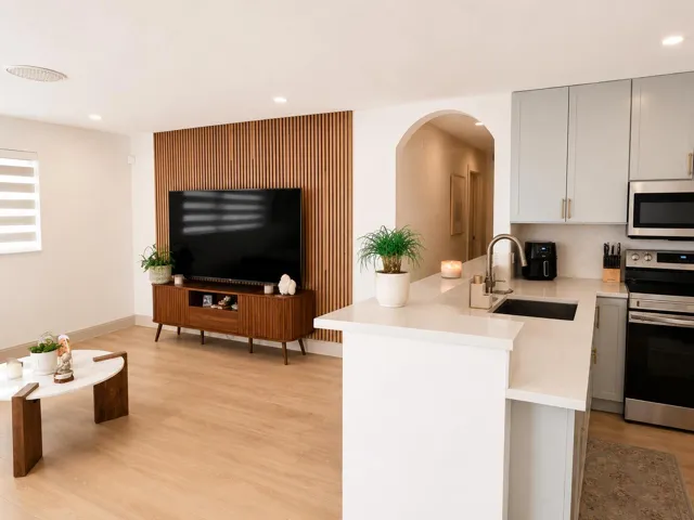 Contemporary kitchen featuring light gray cabinetry, stainless steel appliances, a stainless steel sink with a gooseneck faucet, and light-toned countertops