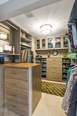 Primary WIC w/ custom bulitouts for maximum storage & glass face upper cabinets
