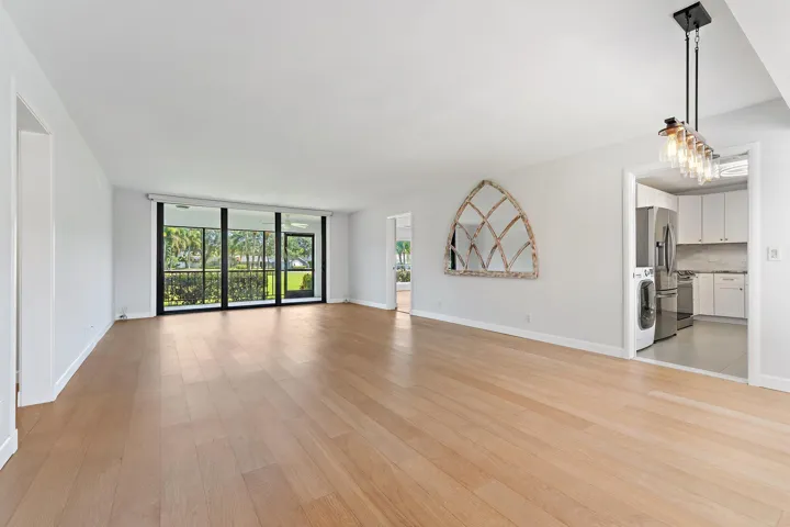 Bright, open living space with new wide-plank floors and sliders out to the green
