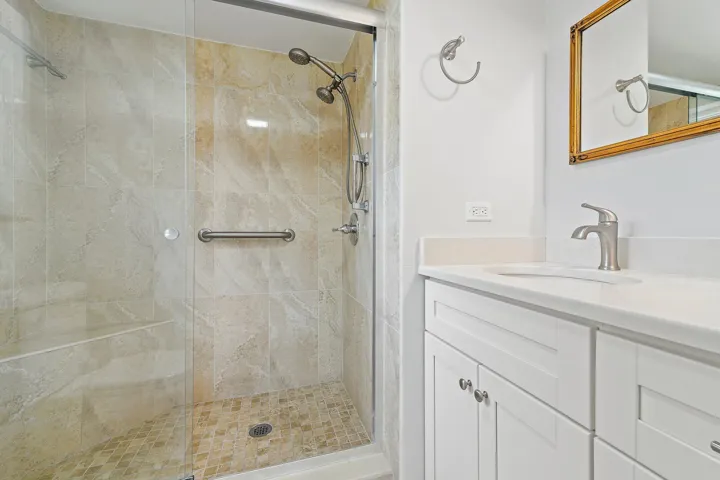 Walk-in shower finished in warm stone