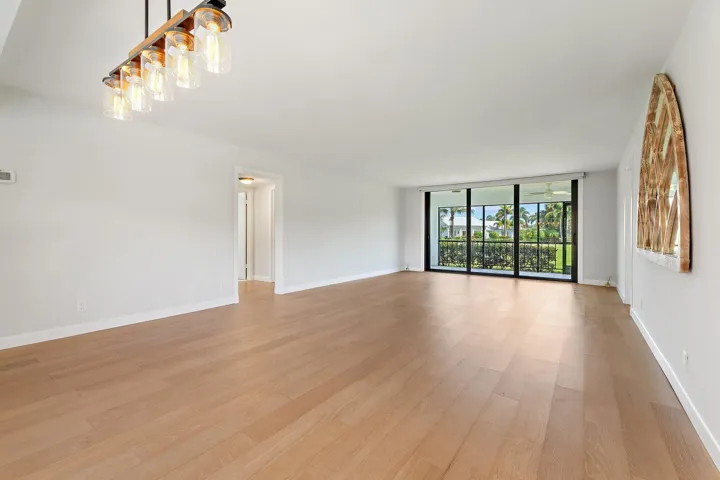 Living room flows to the patio with a quiet golf course backdrop