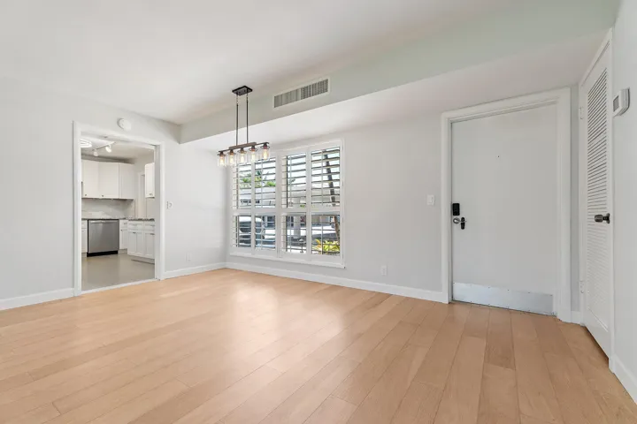 Living and dining area with plantation shutters and warm wood-look flooring
