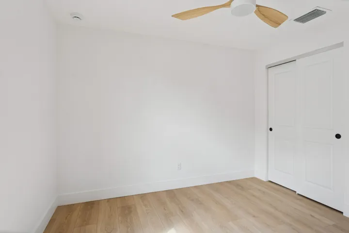 Middle bedroom, headboard, wall, and closet