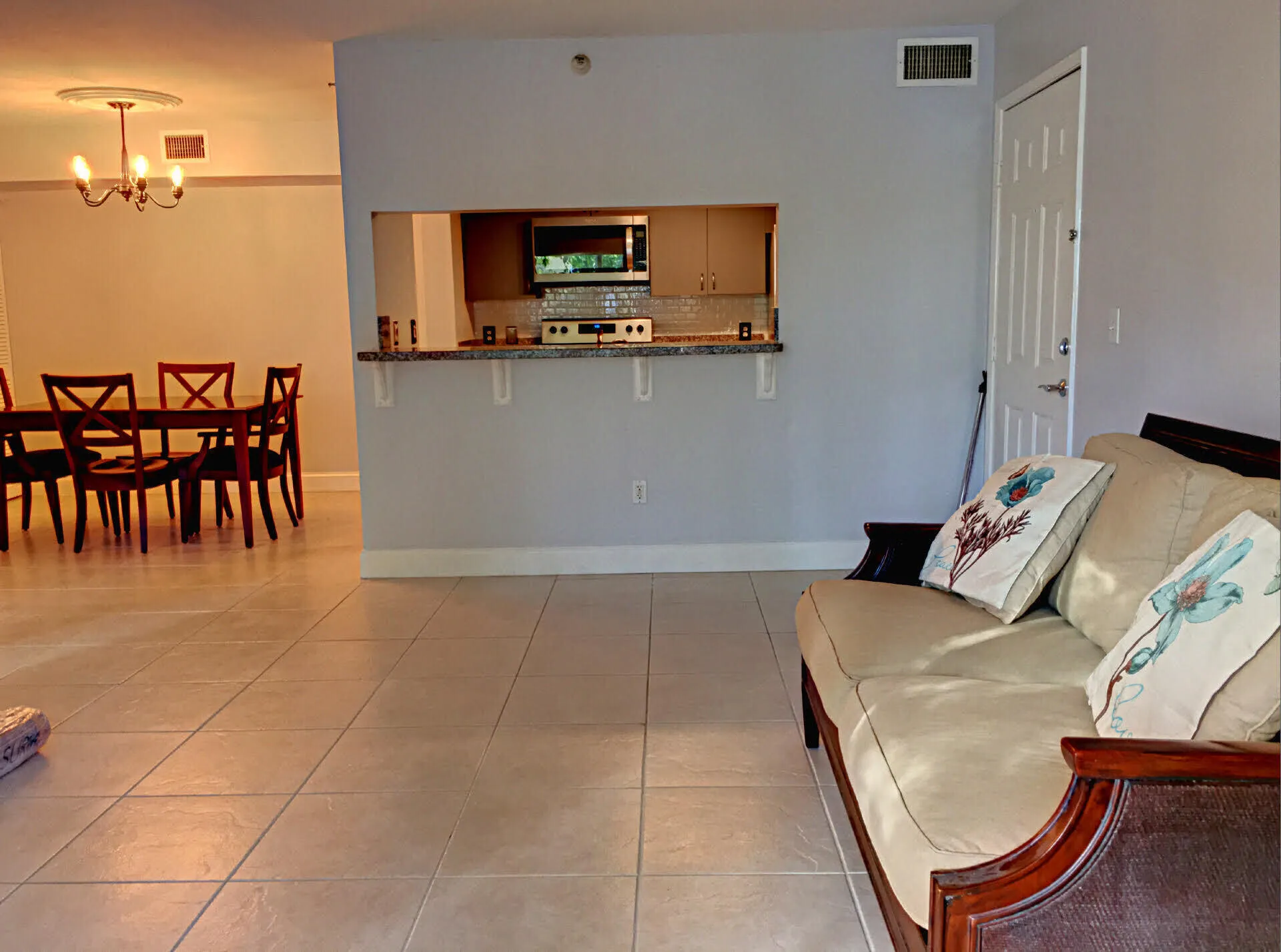 Light-toned tile flooring throughout with a pass-through kitchen opening to the main living area