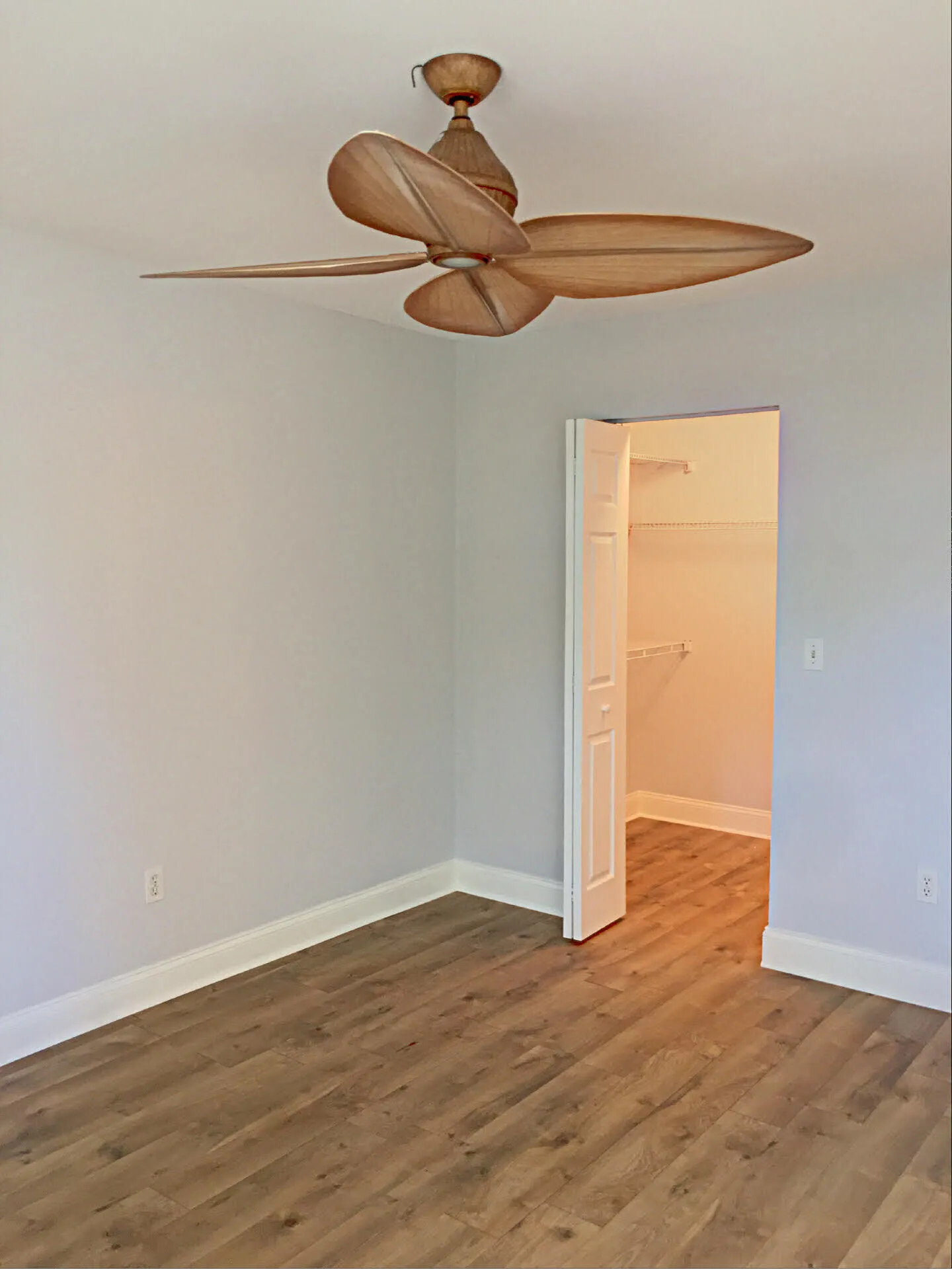 Wood-finish flooring extends throughout this interior space, featuring light gray wall paint and white baseboards