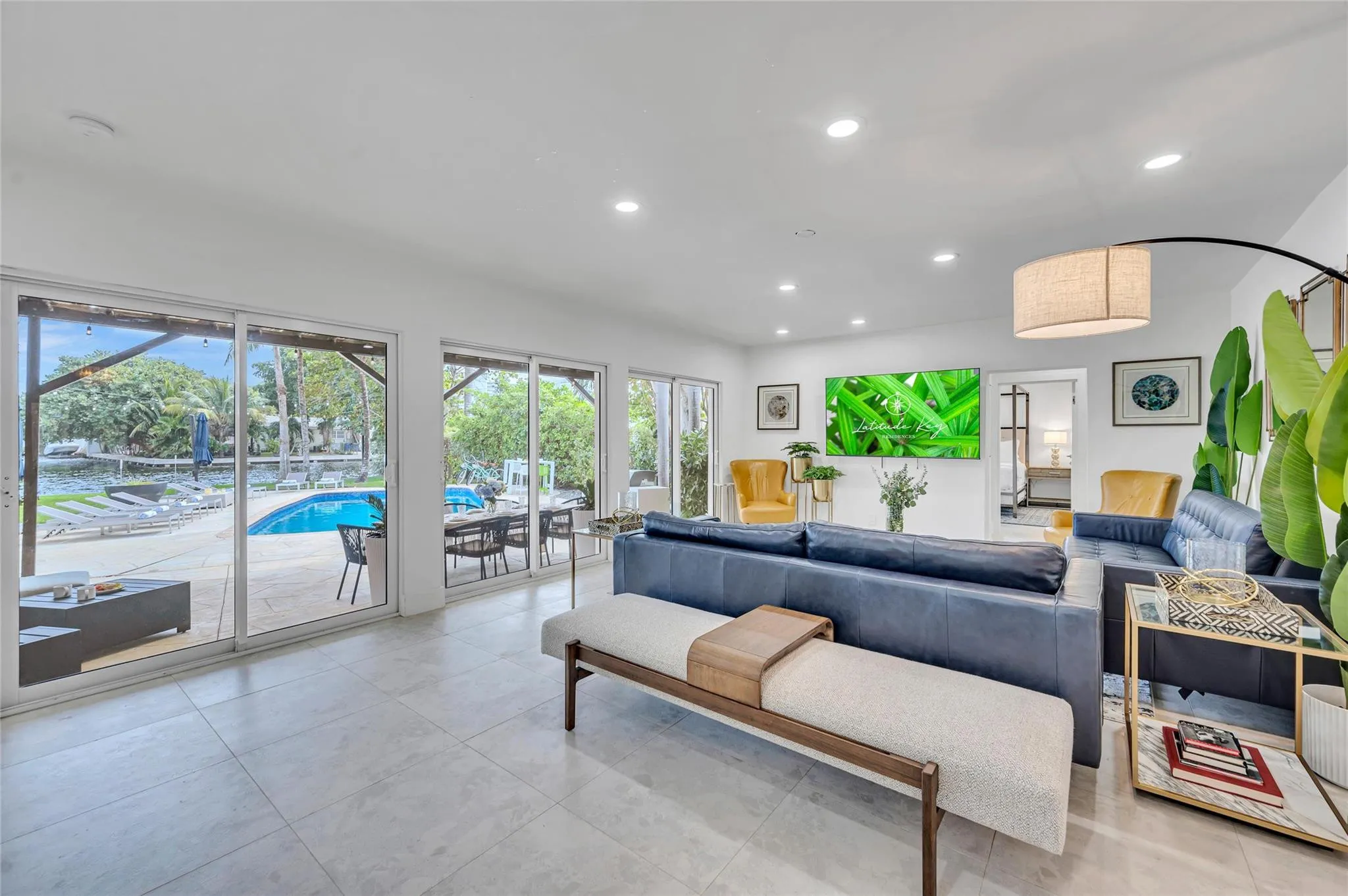 Open concept living and kitchen space with views of the patio, pool, water, and beyond!