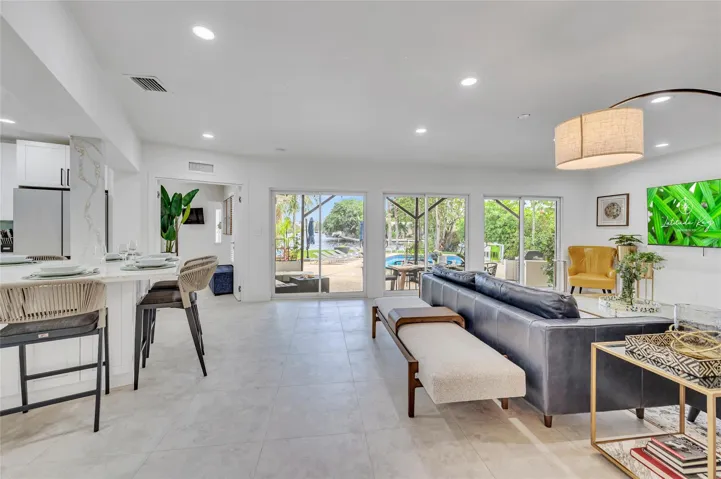 Open concept living and kitchen space with views of the patio, pool, water, and beyond!