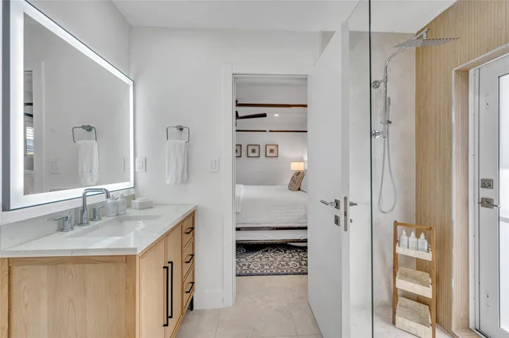 Guest Bathroom - Spa-like dual shower with Moen digital controls connected to high-end Delta Rainfall showerheads with separate handheld. This Bathroom doubles as a Cabana bath with outdoor shower and access to the pool! Vanity with lit mirror and power outlets in the vanity for hair driers etc.