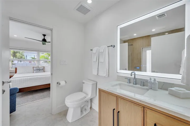 Guest Bathroom - Spa-like dual shower with Moen digital controls connected to high-end Delta Rainfall showerheads with separate handheld. This Bathroom doubles as a Cabana bath with outdoor shower and access to the pool! Vanity with lit mirror and power outlets in the vanity for hair driers etc.