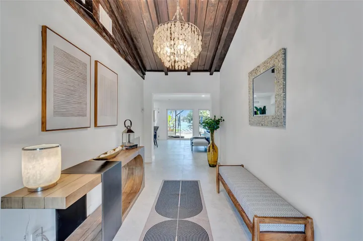 Grand vaulted ceiling entryway invites you into the home with views of the patio, pool, water, and beyond!