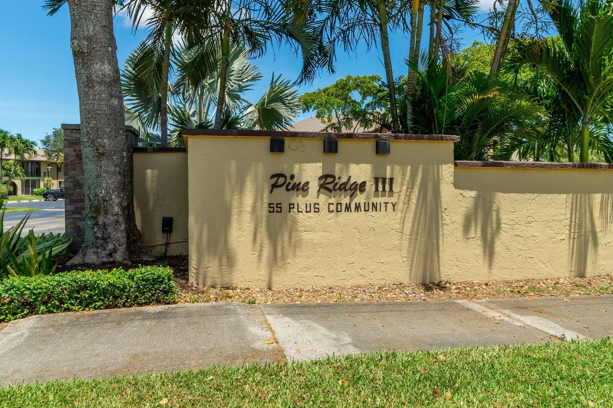 Pine Ridge III community entrance signage featuring a textured stucco finish and integrated lighting