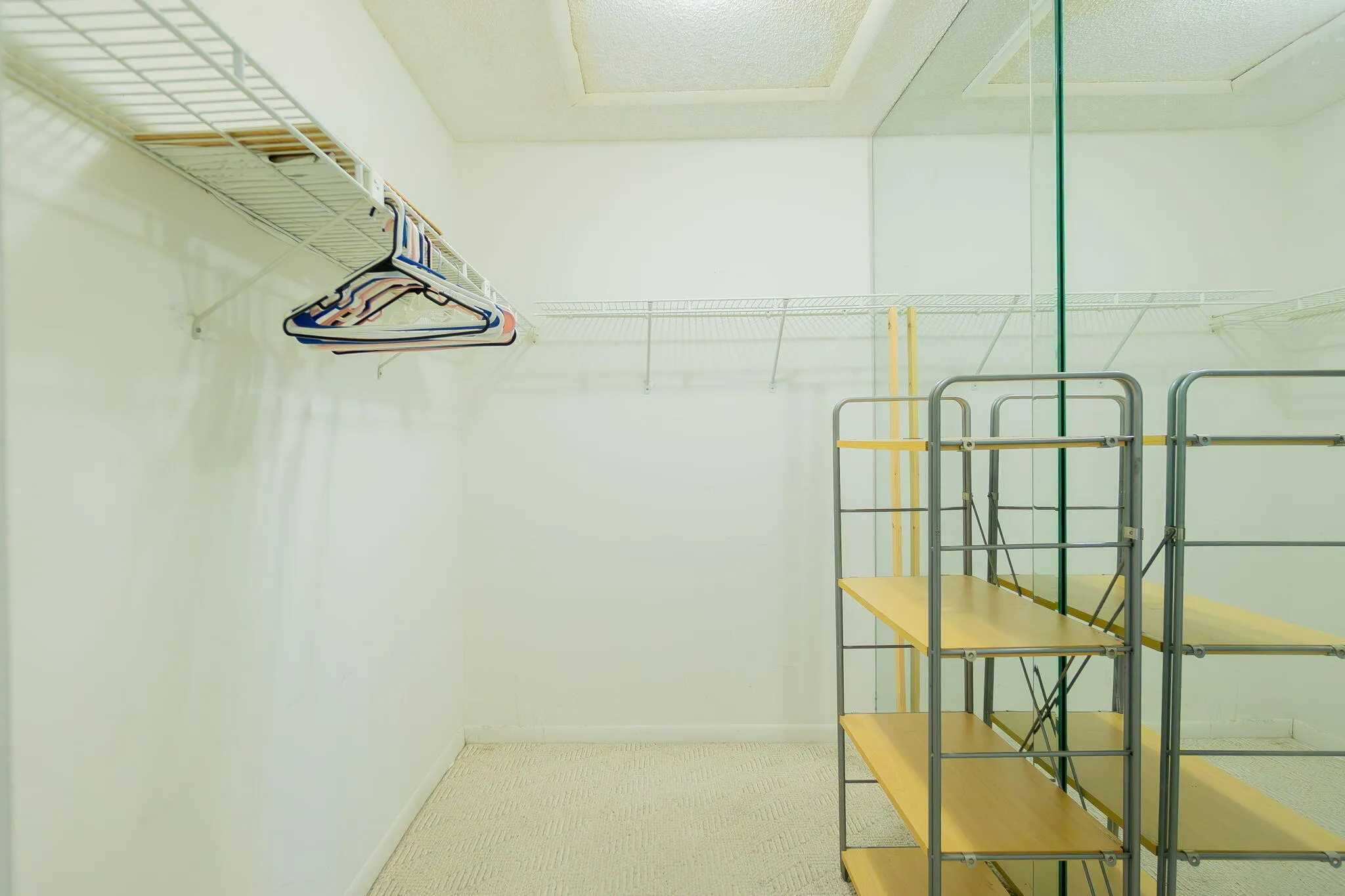 Walk-in closet featuring wire shelving and hanging rods