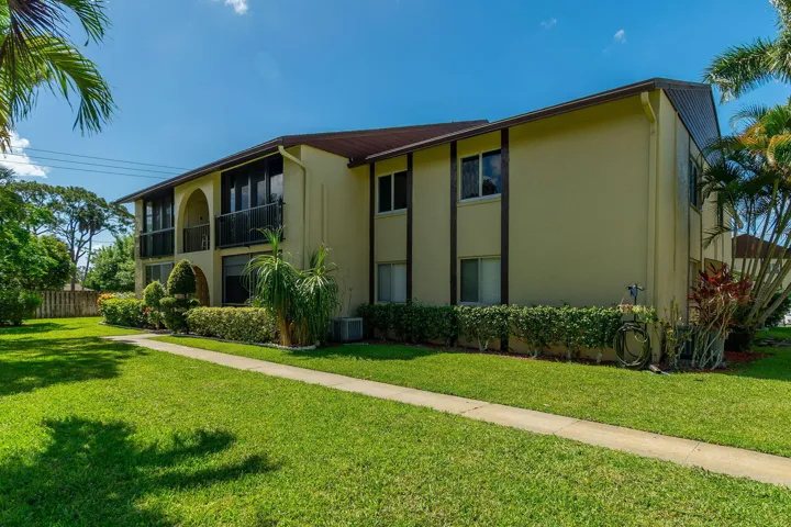 Multi-story stucco exterior with a dark brown roof