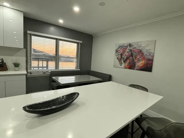Kitchen with white countertop island, recessed lighting, and built-in banquette seating