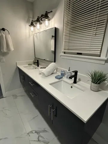 Dual vanity with white countertops, undermount sinks, and matte black fixtures