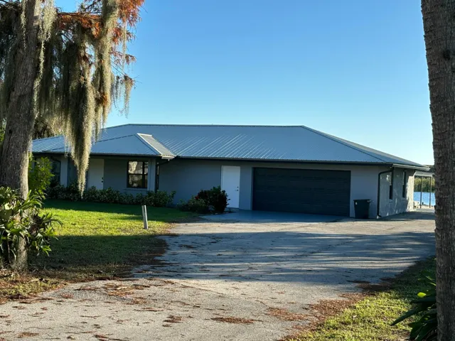 Single-story residence featuring a metal roof, attached two-car garage, and stucco exterior