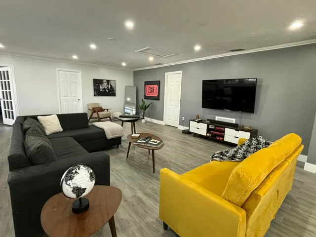 Spacious living area featuring light wood-finish flooring, recessed lighting, and crown molding