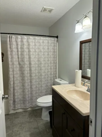 Bathroom featuring a dark wood-finish vanity with an integrated sink and light-toned countertop