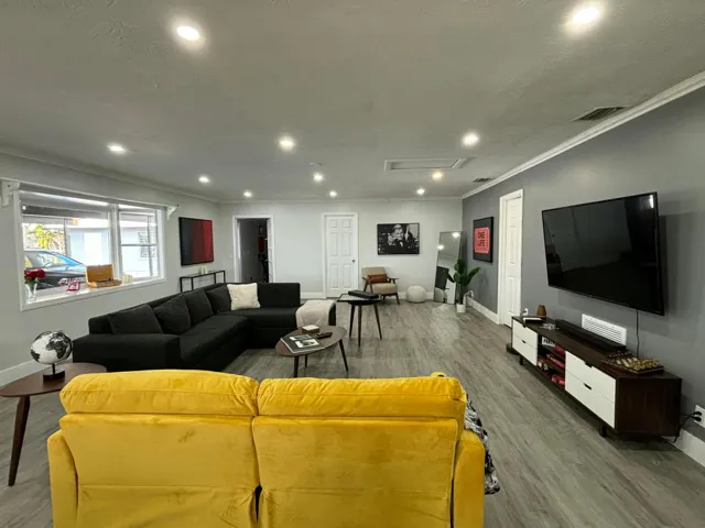 Spacious living area featuring contemporary wood-finish flooring, recessed lighting, and crown molding
