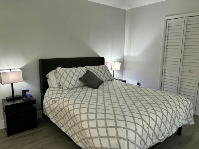 Bedroom featuring light gray wall paint and wood-finish flooring
