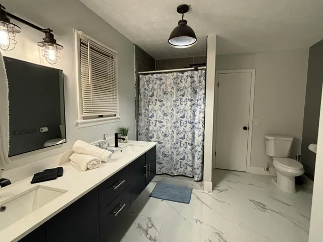 Dual vanity with dark cabinetry, white countertops, and integrated sinks