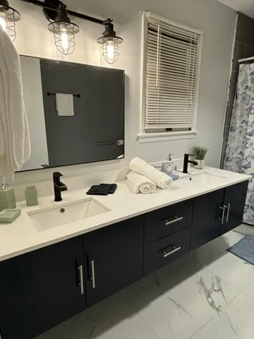 Double vanity featuring two undermount sinks, quartz countertop, and matte black hardware