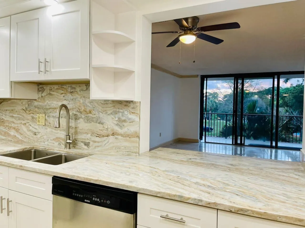 Kitchen featuring white shaker cabinetry, an undermount double-basin stainless steel sink with a gooseneck faucet, and a stainless steel dishwasher